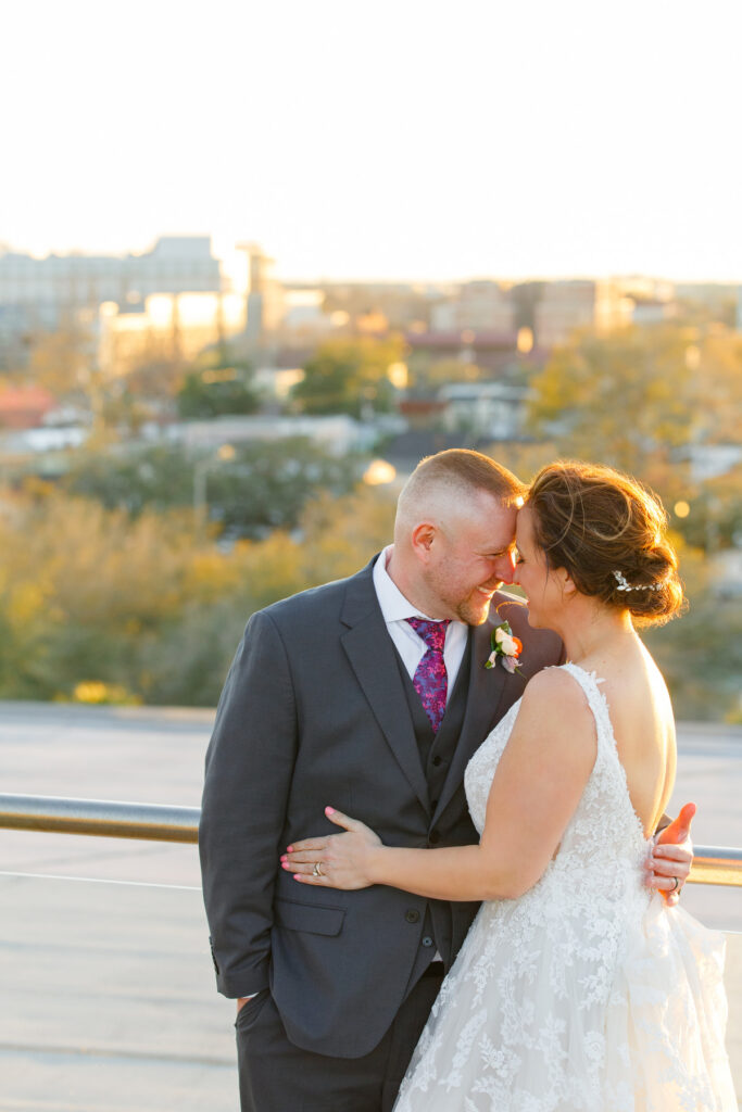 Cedar Room wedding rooftop portrait at sunset of newlyweds nuzzling foreheads together