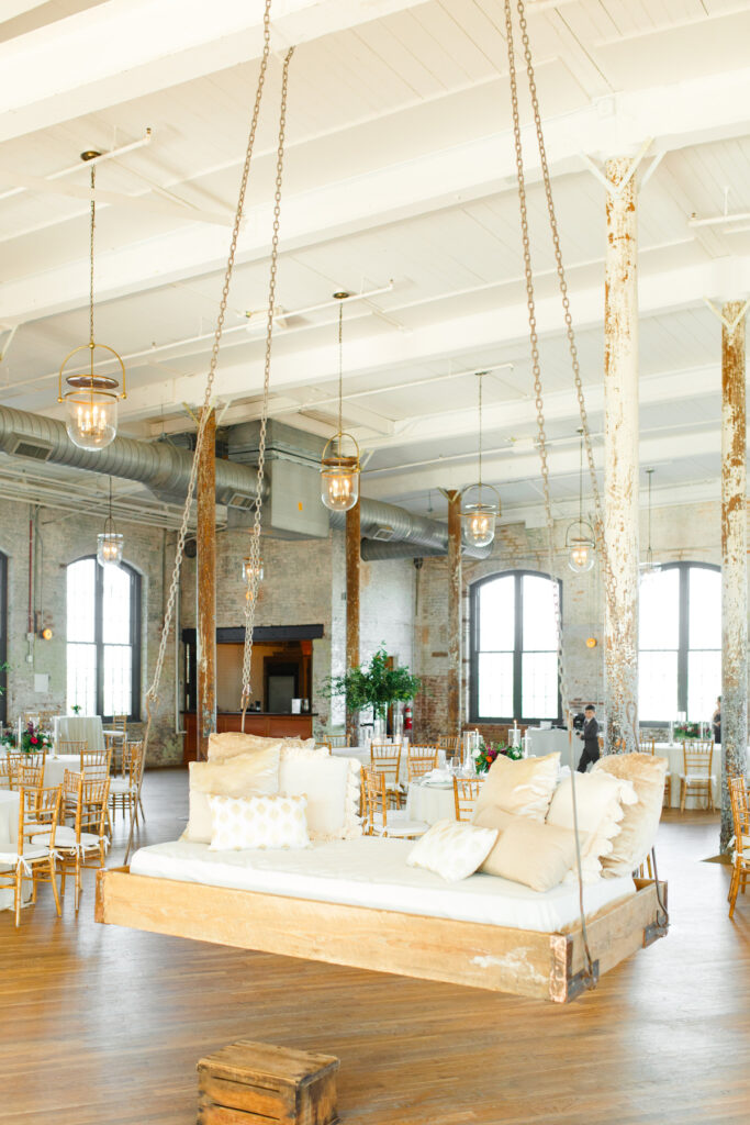 Cedar Room wedding reception with installed bed swing with neutral colored pillows