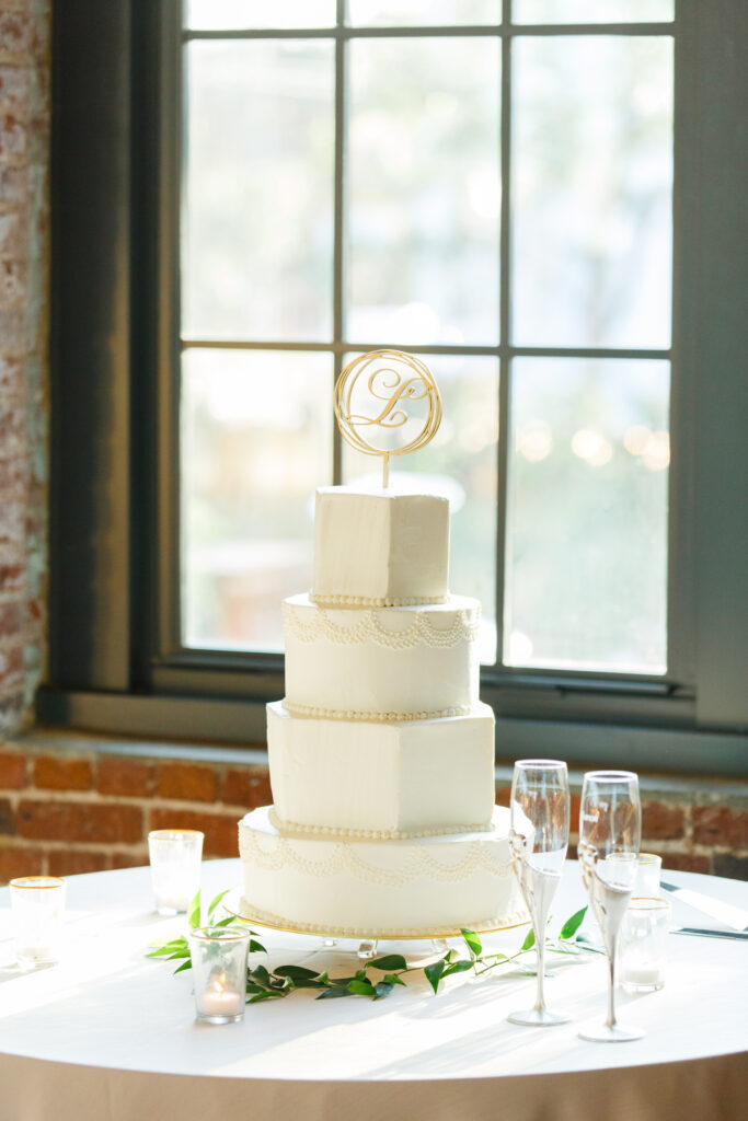 Cedar Room wedding reception with four tier white wedding cake with gold cake topper