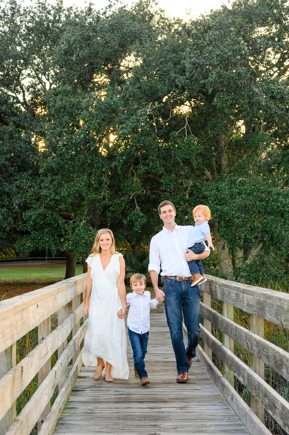 James Island family photo portrait of a mom and dad walking on a wooden pier with their two boys