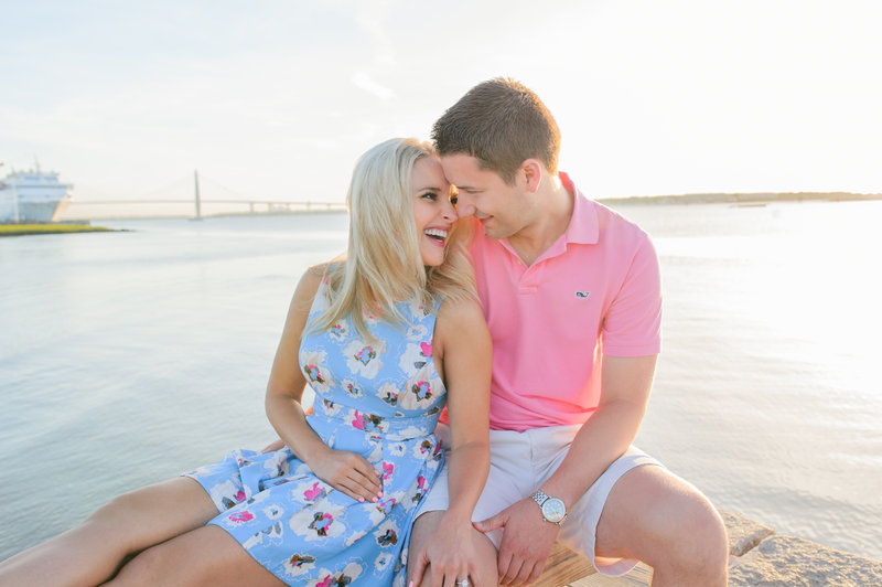 Sunrise Charleston engagement session with blond haired woman in a blue dress with white flowers and a man in a pink polo shirt and white shorts.