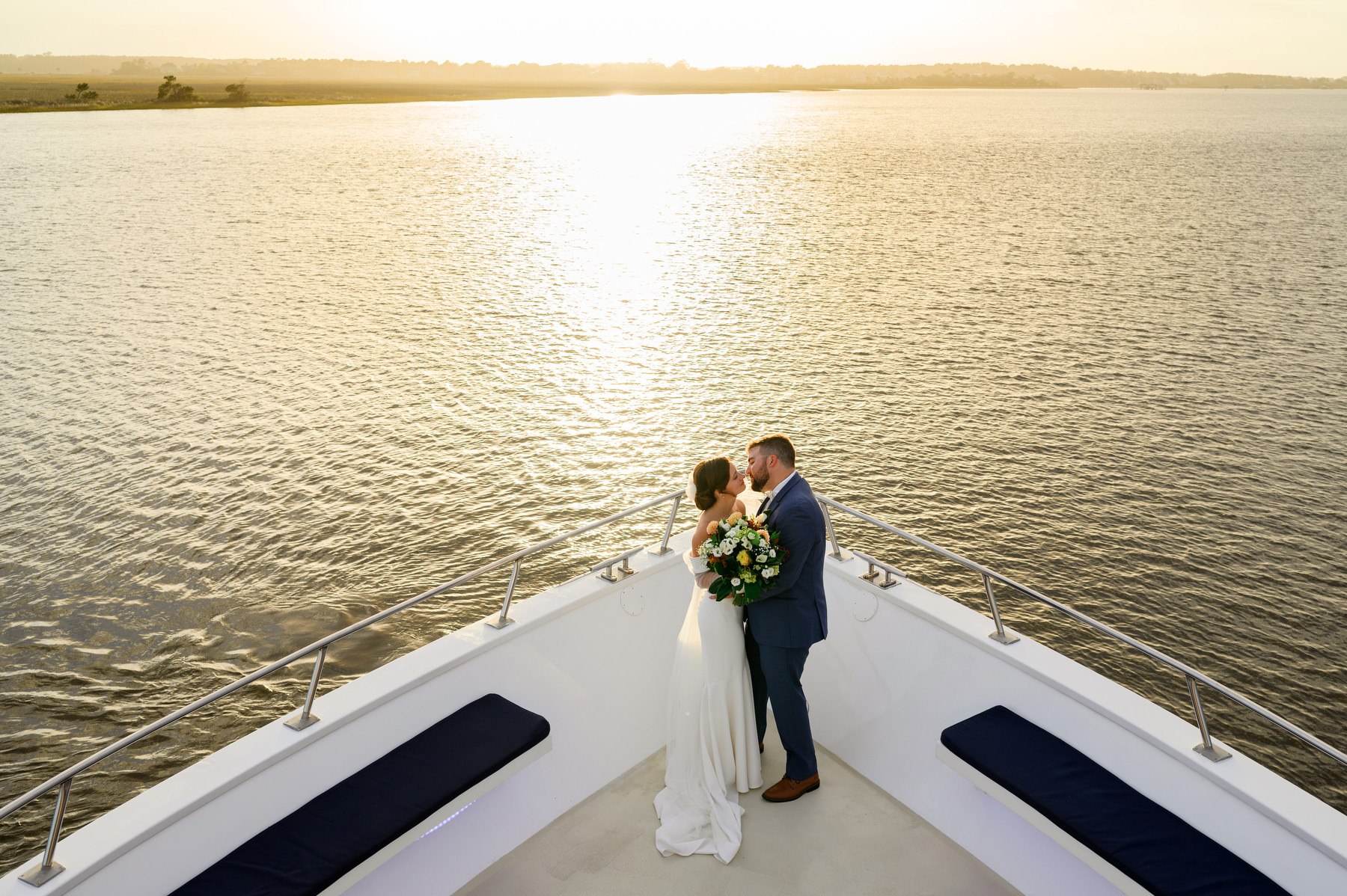 A bride and groom pose for a portrait during their Carolina Girl Yacht wedding in Charleston Harbor