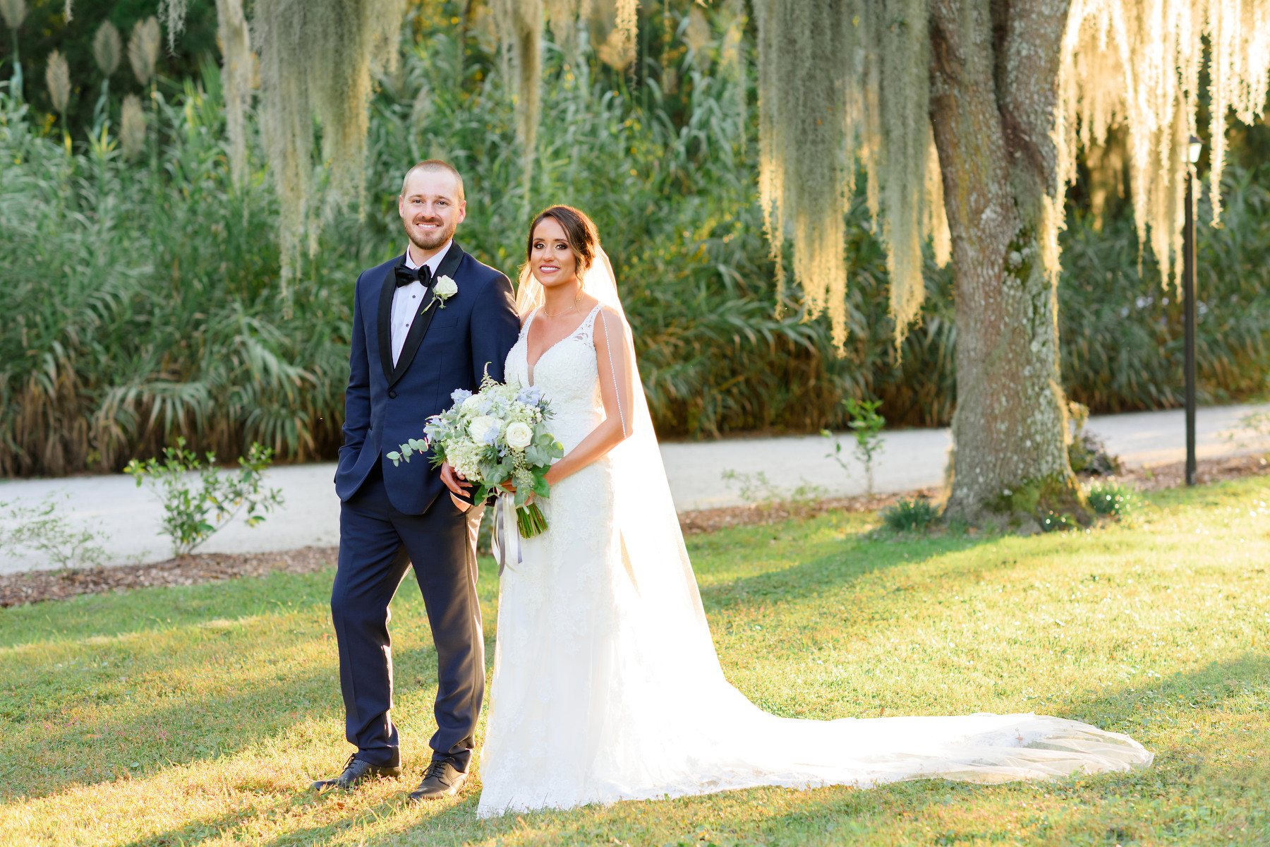 Magnolia Carriage House wedding portrait of groom in a blue tux and the bride in a white dress and veil