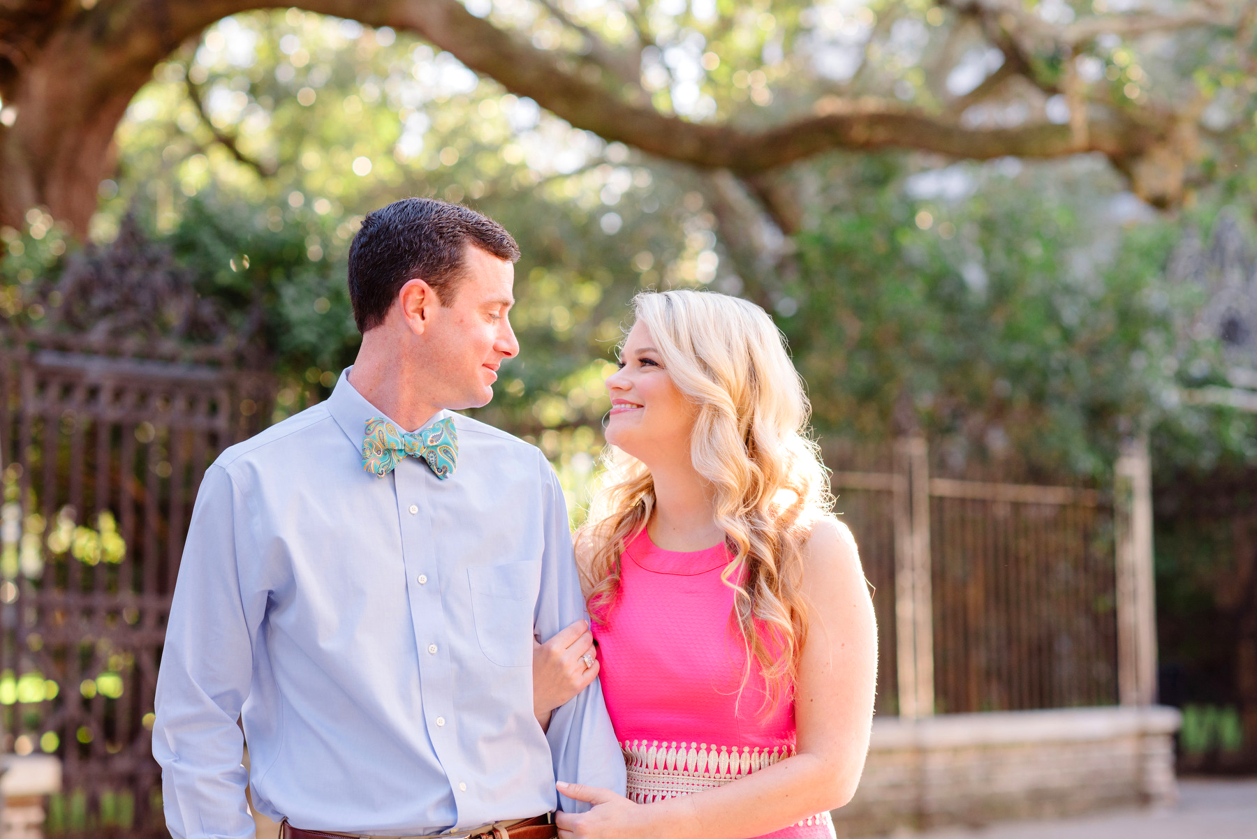 A man and a woman pose for a portrait on Chalmers St during their Charleston French Quarter engagement session.