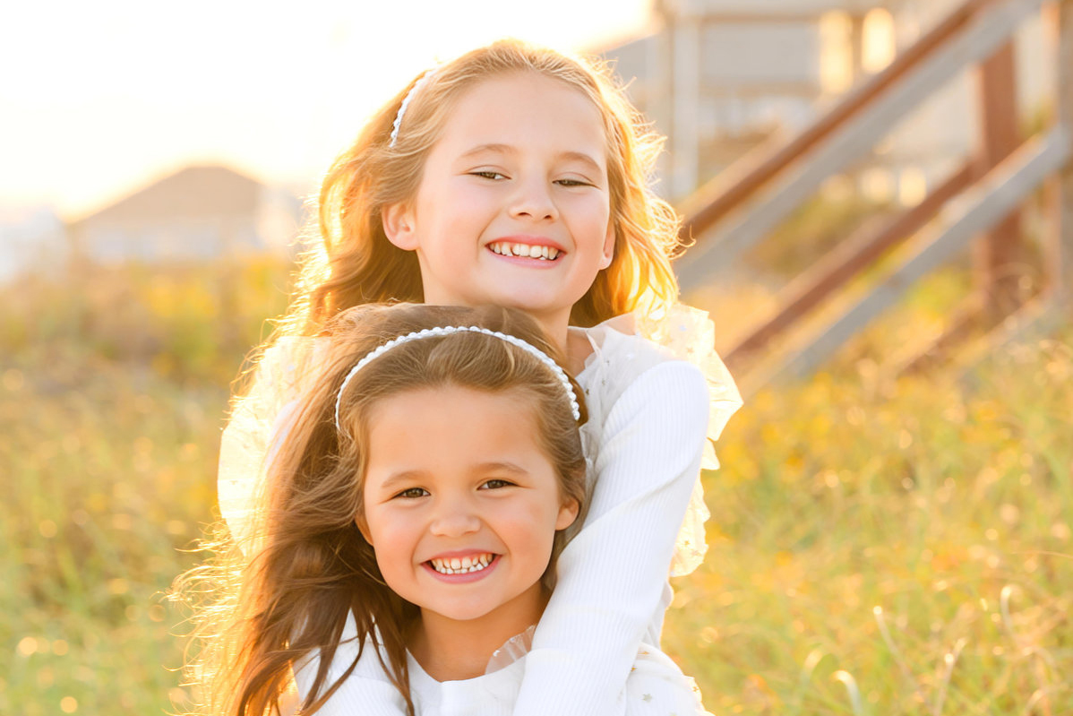 Two sisters pose for a portrait during holiday family photos on Folly Beach, SC