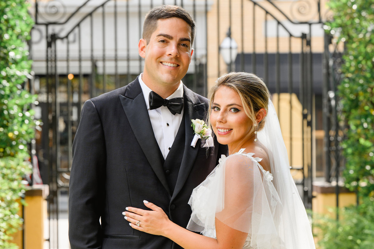 A groom and bride pose for a portrait during their summer William Aiken House wedding in Charleston, SC.