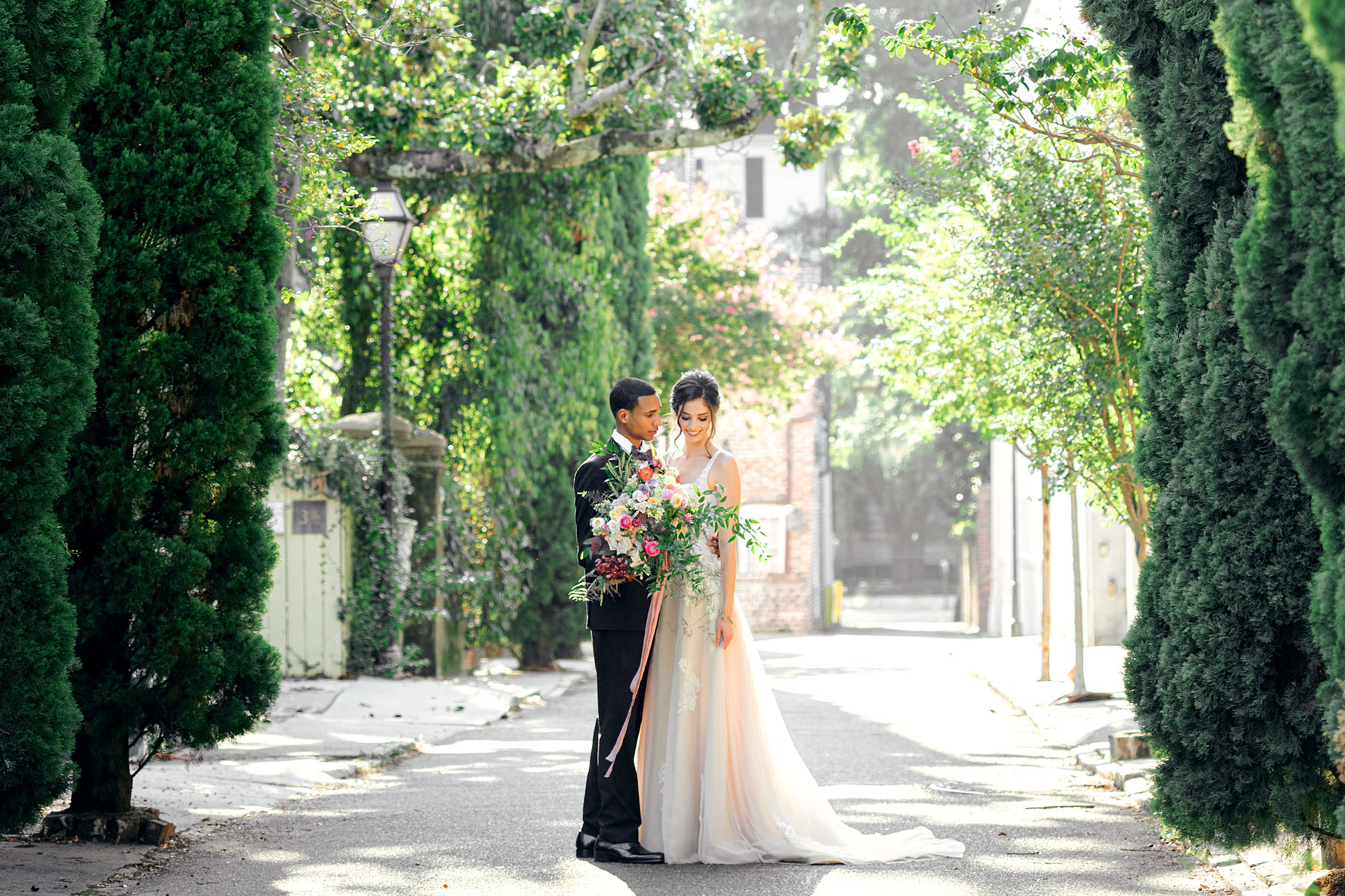 A "bride" and "groom" pose outside during a mocha mousse pantone inspired styled shoot at Society Hall in Charleston, SC.