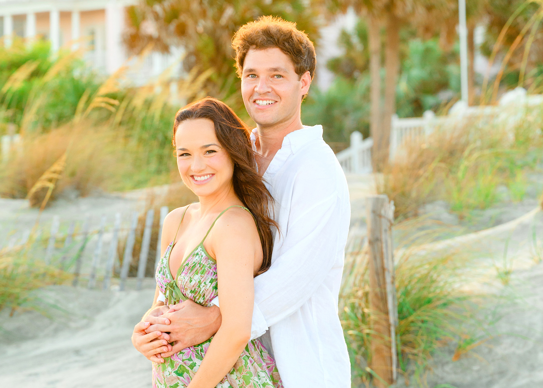 A woman and a man pose on the beach during their Maternity Photos at Wild Dunes