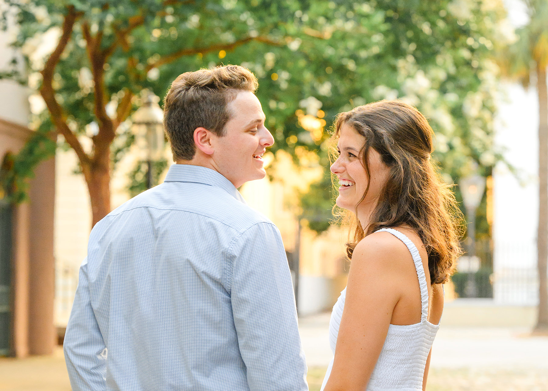 Charleston Summer Engagement Photos-40 Summer Engagement Photos in Charleston with a man in a light blue shirt and a woman in a white maxi dress.